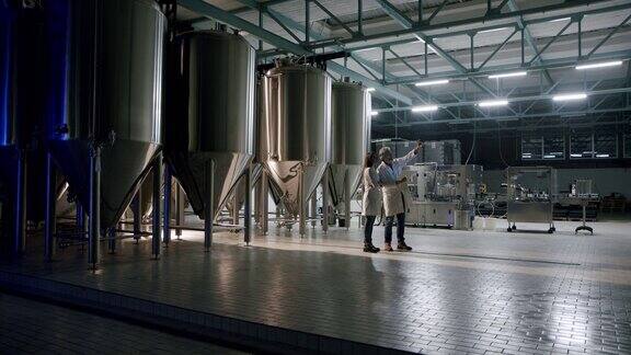 在一家啤酒厂一组员工在检查酿酒厂生产过程中的酒罐