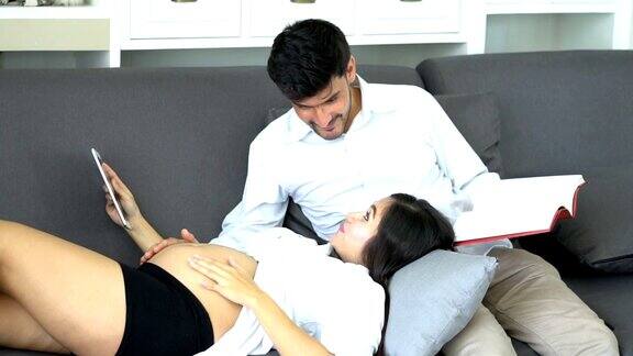 丈夫和孕妇大肚子在家看书