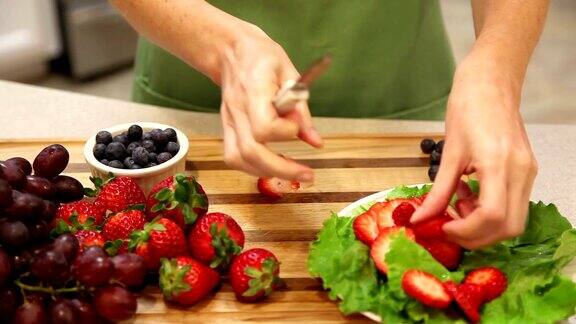 女人在家庭厨房里切草莓