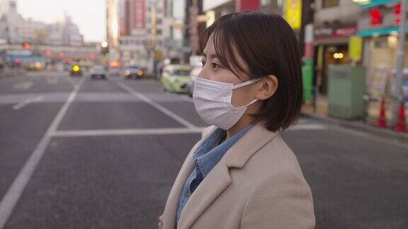 在城市中一名妇女戴着保护面罩穿过街道