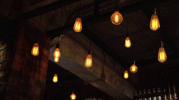 复古复古的黄色灯泡悬挂在咖啡馆晚上的黑暗背景
