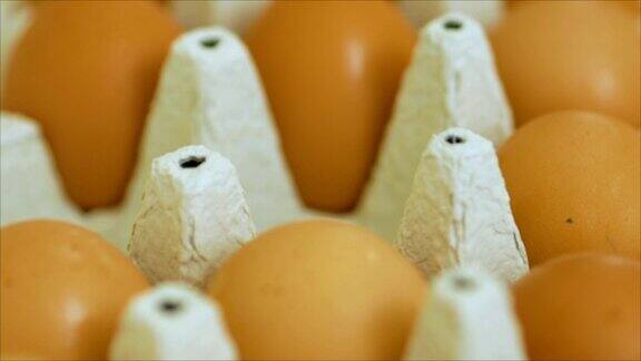 用手把包裹里的鸡蛋折出来接近灰色的鸡蛋纸盒与人把鸡蛋从纸盒