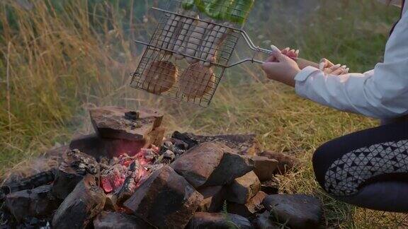 游客用钢格栅在篝火上烤食物