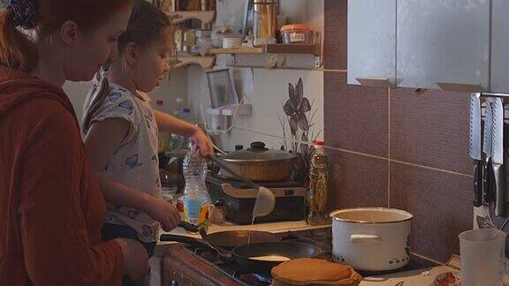 俄罗斯妈妈和女儿在厨房烤煎饼