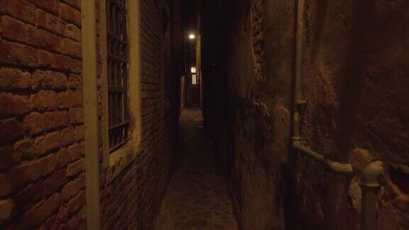 黑暗狭窄的威尼斯通道有灯照明