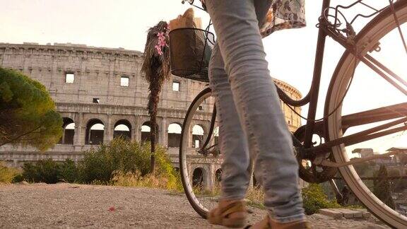 一名骑着自行车的年轻游客用智能手机拍下了罗马斗牛场日落时分的照片漂亮时髦的衣服大帽子鲜花和篮子里的面包