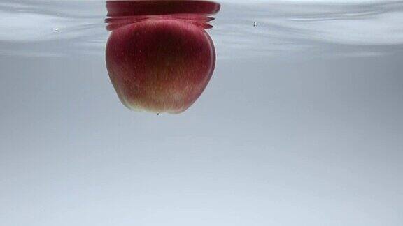 新鲜的苹果果落入水中的慢镜头