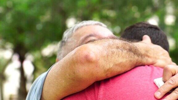 儿子和爸爸爷爷在公园里拥抱