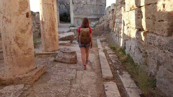 美丽的摄影师游客女孩走在帕穆克卡莱希拉波利斯古遗址的Frontinus门