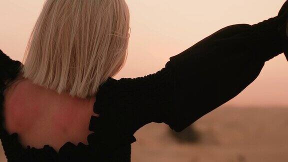 一个女人在沙漠里看日落