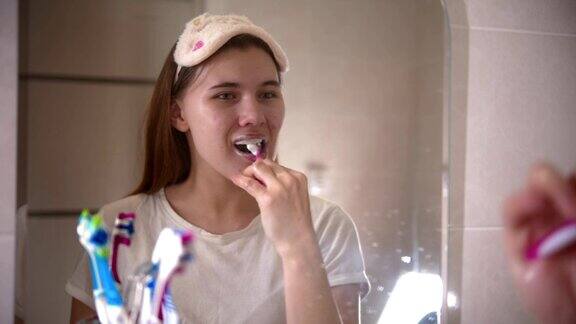 一个年轻漂亮的女人在早上刷牙
