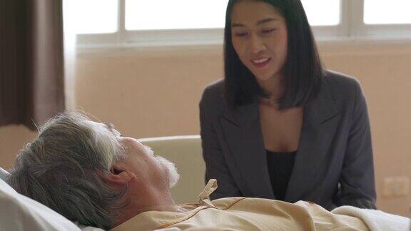 亚洲妇女照顾她生病的父亲在医院恢复室