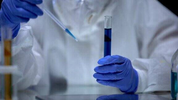 有毒实验室的科学家正在检查蓝色电离辐射液体的危险样本