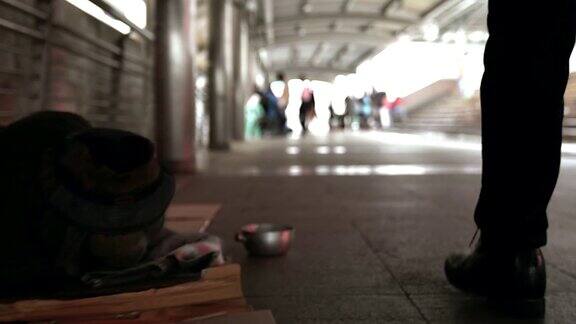 可怜的无家可归者或难民坐在城市街道的地板上社会纪录片