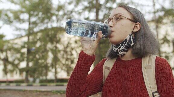 青少年学生戴可重复使用的防护口罩和饮用水