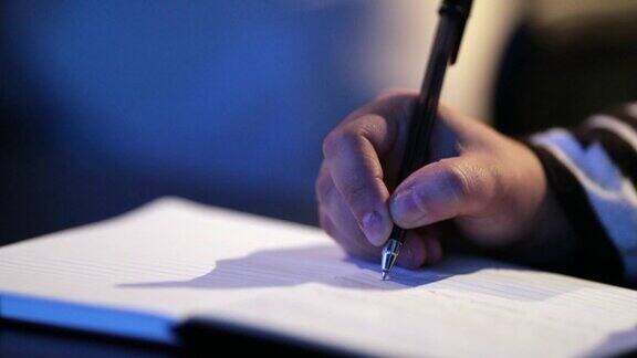 在演讲活动中手握笔在纸上写笔记