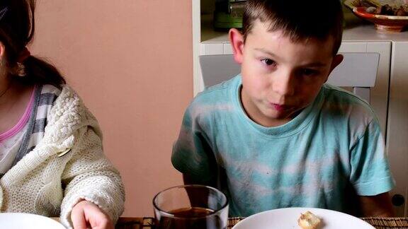 小男孩和小女孩吃零食兄弟姐妹们吃涂在面包卷上的巧克力奶油家庭