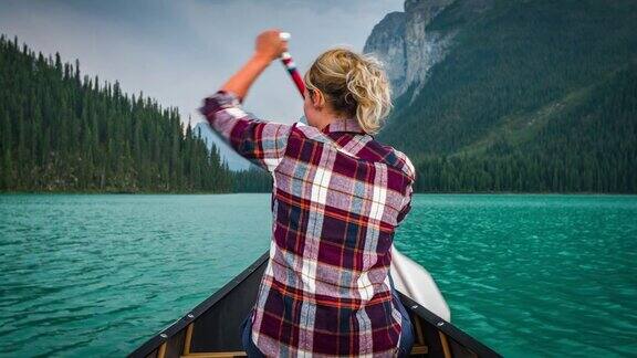 年轻女子在恶性湖上划独木舟