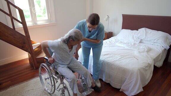 医疗工作者帮助老年妇女坐上轮椅