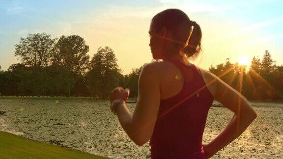 SLOMOTS女人在日落时沿着湖跑