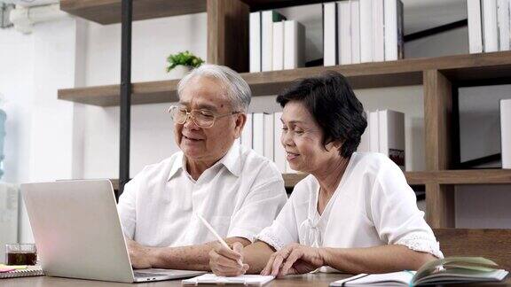 一对老年夫妇在用笔记本电脑理财