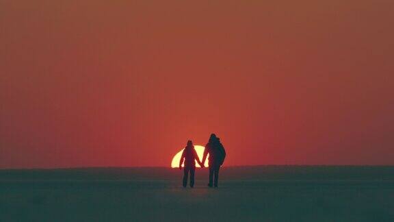 两个旅行者走在美丽的夕阳背景慢动作