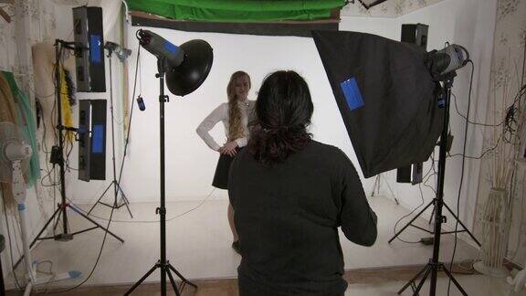 摄影工作室女摄影师与年轻的模特在摄影工作室工作