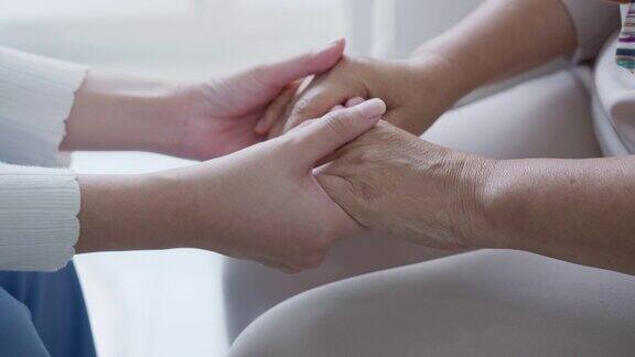 亲密的手年轻的亚洲妇女或护理家照顾老祖母给予支持同情老年妇女或老年人在辅助生活的家庭照顾心理健康救济