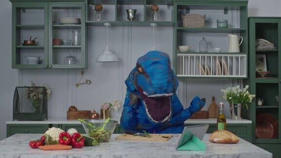 蓝色的大恐龙在厨房里跳舞滑稽动作的人在恐龙吉祥物在家保持积极的情绪