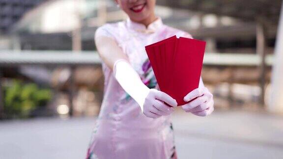 一名十几岁的中国女子将红包交给相机表示春节快乐、富有和幸运