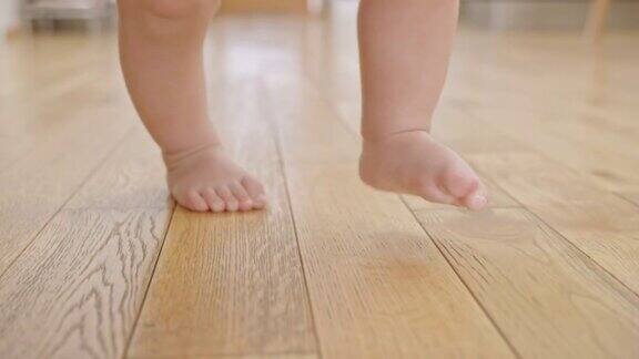 SLOMO婴儿光着脚在木地板上行走