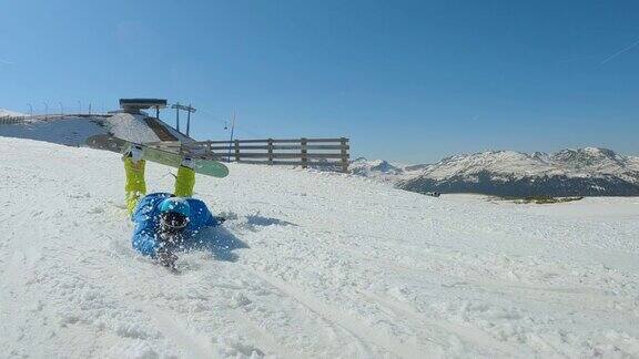 一个年轻人正在学习骑滑雪板突然他在雪地上摔倒了