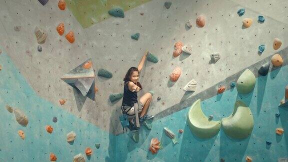 女孩在攀岩馆里攀岩