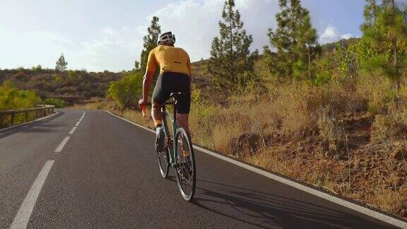 骑自行车的人骑着自行车在开阔的道路上到日落