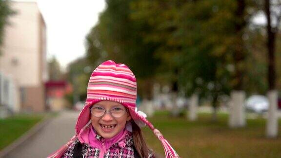 戴眼镜的女学生放学后跑回家女孩高兴得跳着跑缓慢的运动