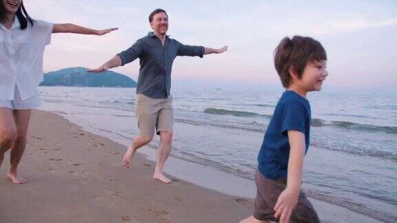 快乐的一家人在周末的沙滩上散步和跑步