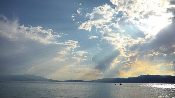 阳光穿过云层海上的人享受他们的假期游泳