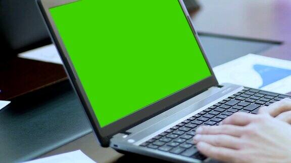 使用绿色屏幕的笔记本电脑使用触控板滚动网页的人