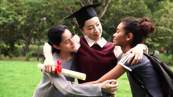 年轻的女毕业生在毕业典礼上拥抱她的朋友国际多元化背景