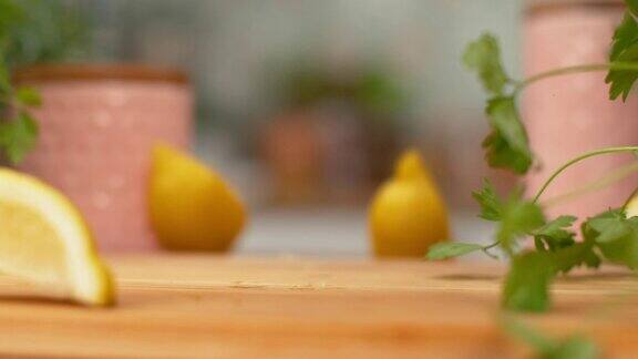 慢镜头微距:切成四等分的新鲜柠檬落在厨房的木制桌子上