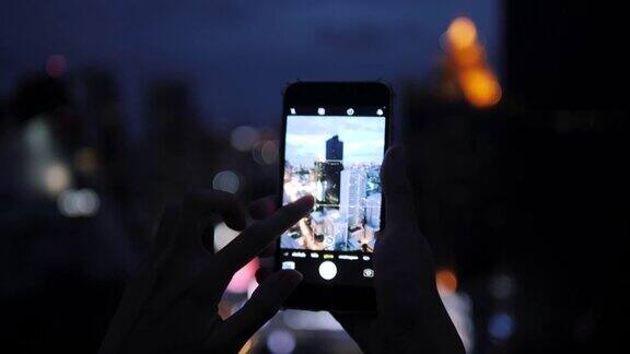 嬉皮士们在晚上用智能手机拍照