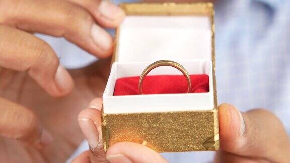 一个年轻人拿着一个盒子里的结婚戒指