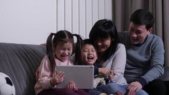 快乐的亚洲家庭在平板电脑上看动画片