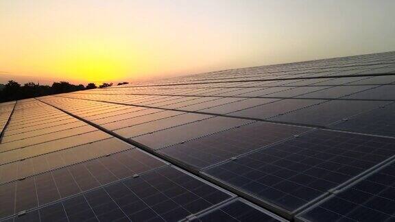 蓝色光伏太阳能电池板安装在建筑屋顶在日落时产生清洁的生态电力生产可再生能源概念