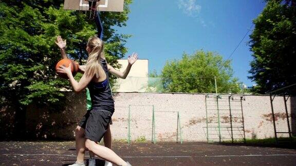 两个女高中生在户外打篮球的慢动作镜头女孩成功地将球射入篮网并得分