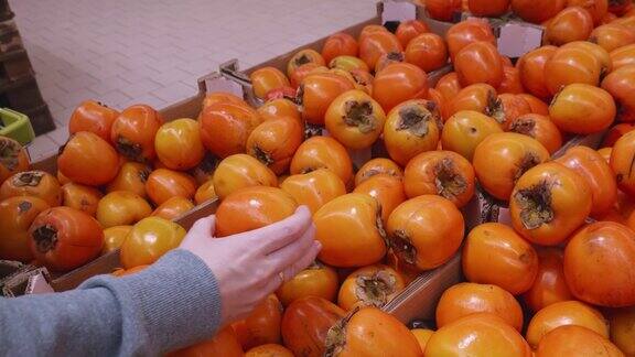在超市里挑选柿子柿子特写