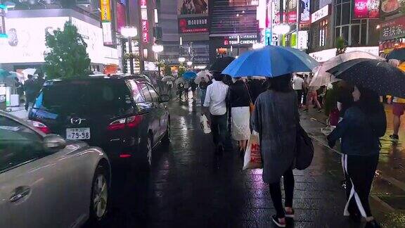 在下雨的时候拥挤的人们在城市里散步、购物和过马路