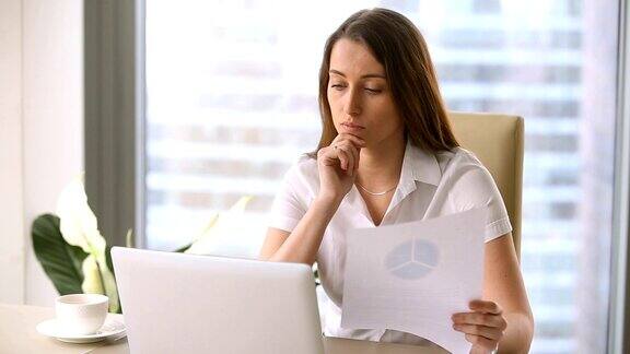 迷人的女商人使用笔记本电脑学习图表做演示做财务报告