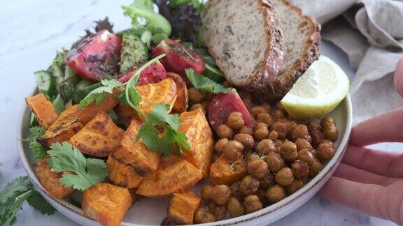 素食午餐:蔬菜沙拉煎鹰嘴豆和烤红薯配健康面包