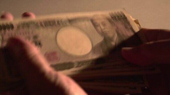 男人喜欢手里的现金男人在数日元钞票
